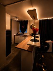 a kitchen with a counter with a vase of flowers on it at Suite O'Dream - Jacuzzi - Cinéma - Climatisation in Fleury-les-Aubrais