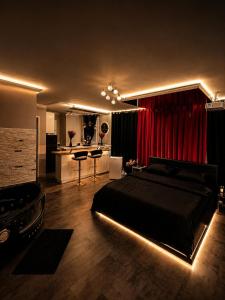 a bedroom with a bed and a red curtain at Suite O'Dream - Jacuzzi - Cinéma - Climatisation in Fleury-les-Aubrais