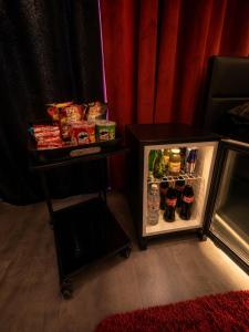 a small refrigerator next to a table with food at Suite O'Dream - Jacuzzi - Cinéma - Climatisation in Fleury-les-Aubrais