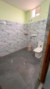 a bathroom with a white toilet and a sink at pnrpalace in Bāpatla