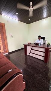 a man sitting at a desk in a room at pnrpalace in Bāpatla