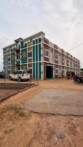 a large building with a parking lot in front of it at pnrpalace in Bāpatla +6 photos