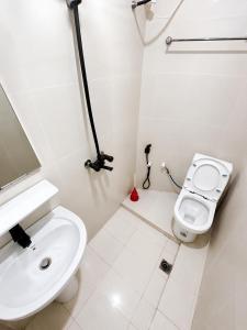 a white bathroom with a toilet and a sink at ZANZInest Apartment in Kituoni +14 photos