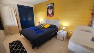 a bedroom with a bed with a painting on the wall at Shanti Om Refúgio Pousada e Yoga in Cascavel +58 photos