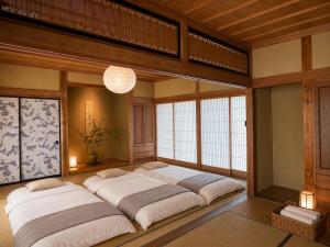 a large room with four beds in it at 貸切り200m2 林檎のワルツ 広い和モダン邸宅 星空とBBQ in Komoro