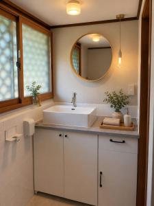 a bathroom with a white sink and a mirror at 貸切り200m2 林檎のワルツ 広い和モダン邸宅 星空とBBQ in Komoro +21 photos