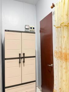a closet with ajar doors and a refrigerator at Amori Spaces - MRG in Maribago