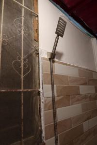 a shower in a room next to a door at Amori Spaces - MRG in Maribago