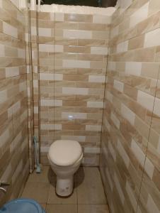 a bathroom with a toilet in a room with tiles at Amori Spaces - MRG in Maribago