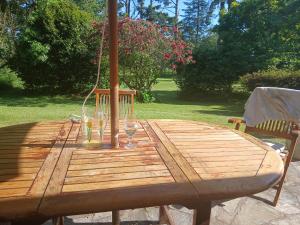 a wooden table with a glass of wine on it at Chambre d hote bucolique in Mahalon