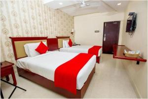 a hotel room with two beds and a television at Hotel President in Madurai
