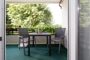 a table and chairs on a porch with a tree at Waldstraße 2 Ferienwohnung Volkenborn in Kellenhusen