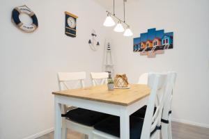 a dining room with a table and white chairs at Waldstraße 2 Ferienwohnung Volkenborn in Kellenhusen
