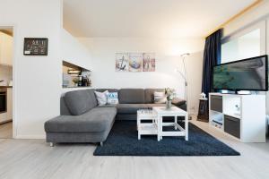 a living room with a couch and a tv at Waldstraße 2 Ferienwohnung Volkenborn in Kellenhusen