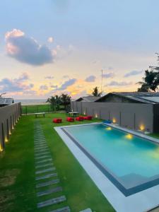 a large swimming pool with a view of the ocean at Trident Sea Hotel in Negombo