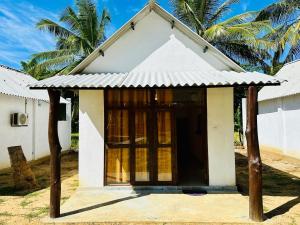 a small white house with a door in front at All View Safari Cottage in Timbulketiya