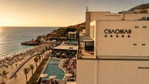 a view of a resort with a swimming pool and the ocean at Chaonian Hotel in Dhërmi