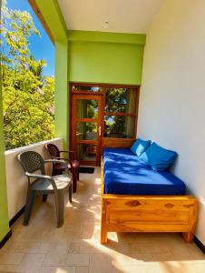 a bedroom with a bed and a chair and a window at Eagle Resort Arugambay in Arugam Bay +4 photos