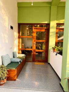 a living room with a green wall and a door at Eagle Resort Arugambay in Arugam Bay