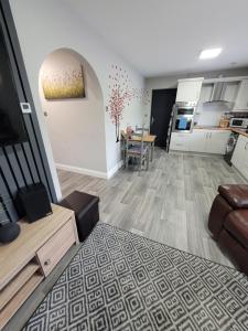 a living room with a couch and a kitchen at Rose Cottage Clonmel in Clonmel
