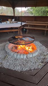a fire pit with a chain hanging over it at Domki u Grega na kaszubach in Wiele