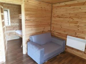 a room with a chair in a log cabin at Domki u Grega na kaszubach in Wiele