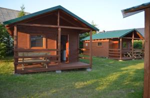 a large wooden cabin with a green roof at Domki u Grega na kaszubach in Wiele