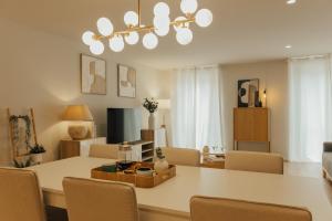a dining room and living room with a table and chairs at Gerês Thermae Retreat in Geres