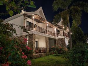 a large white house with a balcony at night at Vangvieng Lina hotel in Vang Vieng