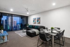 a living room with a table and a couch at Circle on Cavill Apartments - Hosted by WowStay in Gold Coast