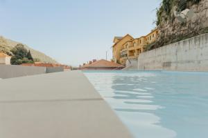 a pool of water with buildings in the background at Gerês Thermae Retreat in Geres