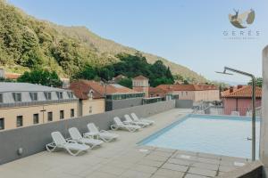 a group of lounge chairs and a swimming pool at Gerês Thermae Retreat in Geres