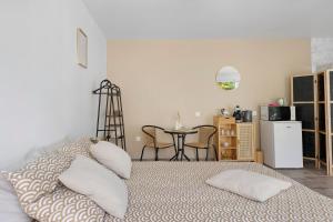 a bedroom with a bed with pillows and a table at La Parenthèse du Loir in Château-du-Loir