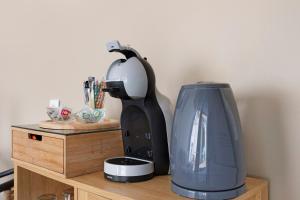 a coffee maker sitting on top of a wooden table at La Parenthèse du Loir in Château-du-Loir