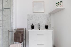 a white bathroom with a sink and a shower at La Parenthèse du Loir in Château-du-Loir +17 photos