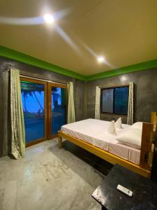 a bedroom with a bed and a window at Kapunoan Beach House in Burgos +40 photos