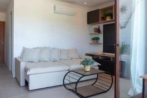 a living room with a white couch and a table at Casa BACO - Morro de São Paulo in Cairu