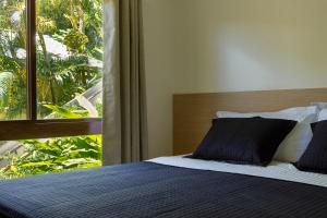 a bedroom with a bed with a large window at Casa BACO - Morro de São Paulo in Cairu