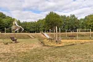 a park with a playground with a slide at Logis des gourmets in Hommes