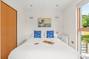 a bedroom with a large white bed with blue pillows at House 6 in Looe +26 photos