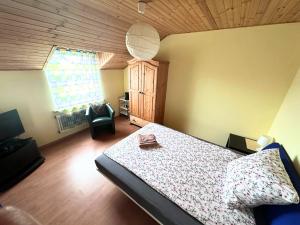 a bedroom with a bed and a chair and a window at Asetech Janny in Pasym
