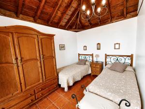 a bedroom with two beds and a large wooden cabinet at Tomasín in Puntallana +19 photos