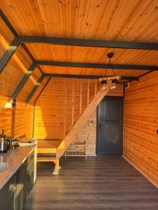 a room with a wooden ceiling with a staircase at Deniz Üstü Bungalov in Fındıklı