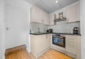 a kitchen with white cabinets and a sink at Albion Apartment by Klass Living Coatbridge in Coatbridge
