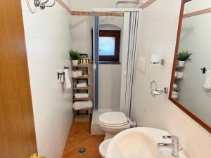 a bathroom with a toilet and a sink and a mirror at La Maisonette di Paestum - Vicino ai Templi & Wi-Fi gratuito in Paestum