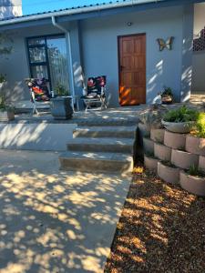 a house with a staircase leading to a wooden door at House Foxglove in Paarl