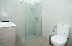a bathroom with a shower with a toilet and a sink at Famara Marea 2 in Famara +12 photos