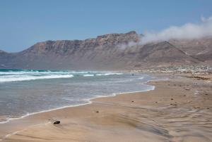 a beach with a mountain in the background at Famara Marea 2 in Famara