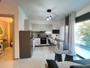 a kitchen with a refrigerator and a table and chairs at Kohyli in Lefkada