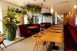 a restaurant with wooden tables and chairs and plants at Resort Aurum in Černý Dŭl